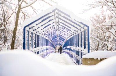 Students walk across the blue Little Mac Bridge amongst the results of a recent snowfall.